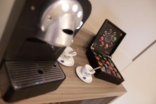 a table with a coffee maker and a box of shoes at ibis Styles Clermont-Ferrand Aéroport in Clermont-Ferrand