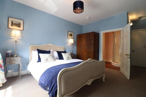 a bedroom with a large bed with blue walls at The Oakhill Inn in Shepton Mallet