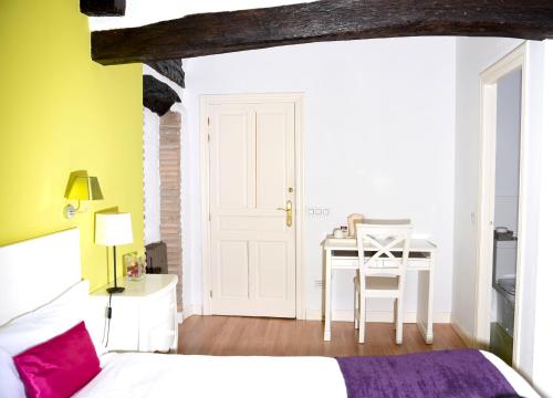 a bedroom with a bed and a table with a chair at Hospedería Señorío de Briñas in Briñas