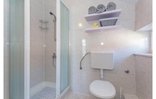 a white bathroom with a toilet and a shower at Bijela Villa in Slano