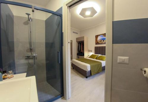 a bathroom with a shower and a bedroom with a bed at YEASY smart rooms Cefalù in Cefalù