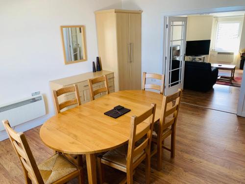 a dining room with a wooden table and chairs at Cunard Apartments in Douglas