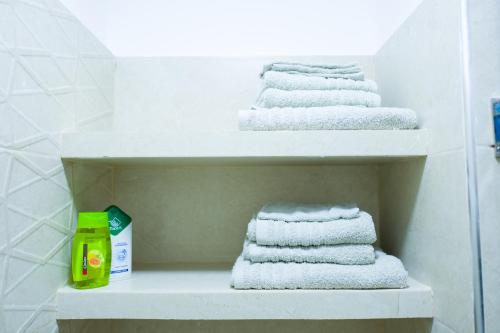 four towels on a shelf in a bathroom at My Cosy Place Rabat - RABAT AGDAL GARE TGV ARRIBAT Center in Rabat