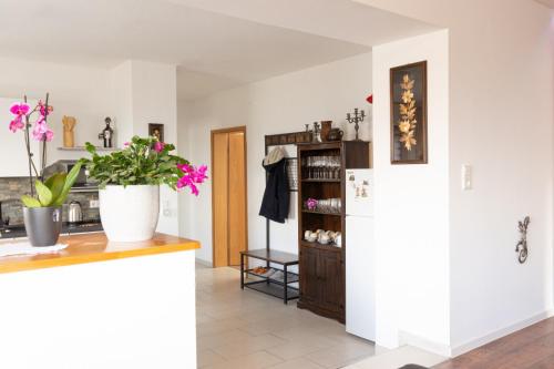 a kitchen with a white refrigerator and flowers on a counter at Haus Elena in Bestwig