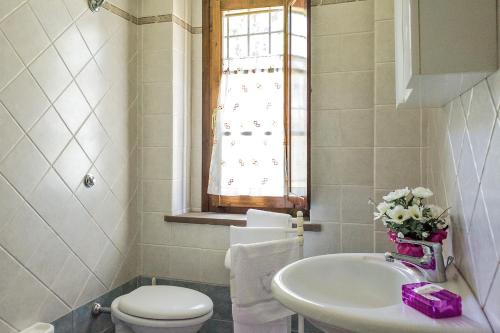 a bathroom with a sink and a toilet and a window at La Casanuova in Laiatico