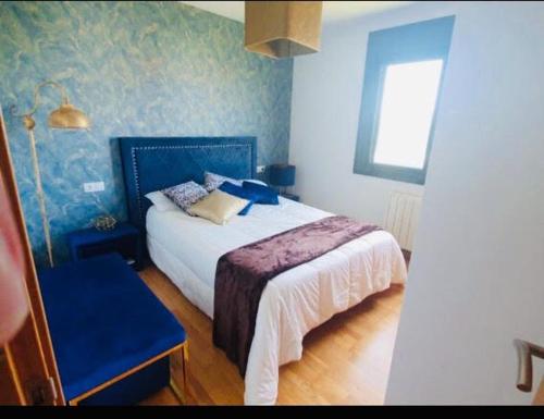 1 dormitorio con 1 cama con pared azul en Apartamento Rodeira, en A Illa de Arousa