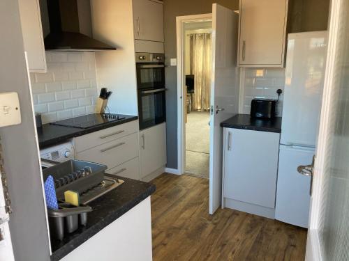 a kitchen with white appliances and wooden floors at Wristland Court, Watchet in Watchet