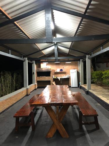 a large wooden picnic table in a covered patio at CHACARA SANTA RITA in Extrema