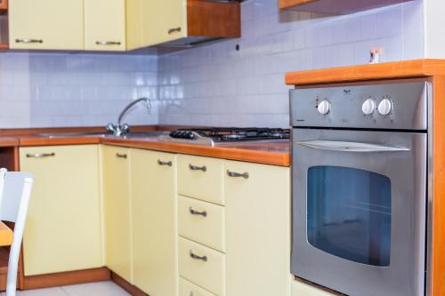 a kitchen with white cabinets and a stove top oven at Residence Daniele in Bellaria-Igea Marina