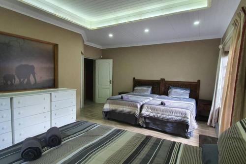 1 dormitorio con 2 camas, vestidor y tocador en Tranquillity Holiday Home, en Marloth Park