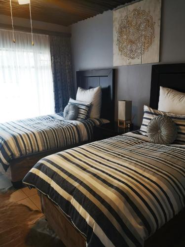 two beds sitting next to each other in a bedroom at Sasavona Game Lodge in Warmbaths