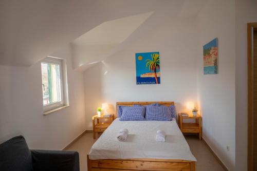 a bedroom with a bed with blue pillows at Beach Apartments Marijana in Vodice