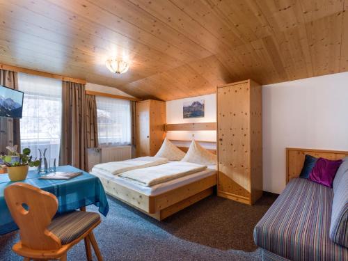 a bedroom with a bed and a desk in a room at Gästehaus Roland in Kirchberg in Tirol