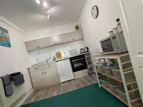 uma cozinha com um frigorífico e um fogão forno superior em Barracuda, Beachside Apartment em Benllech