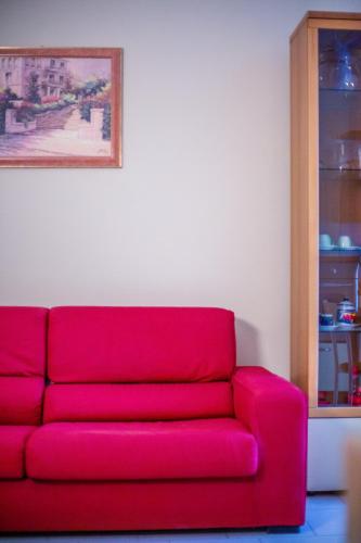 a red couch in a living room with a painting at Residence Daniele in Bellaria-Igea Marina