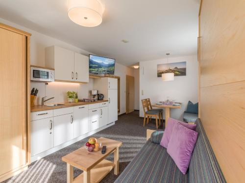 a kitchen and living room with a couch and a table at Gästehaus Roland in Kirchberg in Tirol