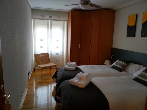 pokój hotelowy z dwoma łóżkami i krzesłem w obiekcie Greta Etxea w mieście Arróniz