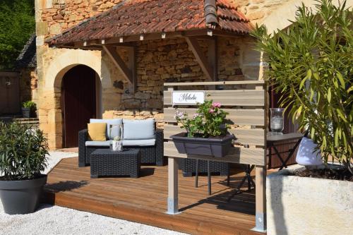 a wooden deck with a gazebo with chairs and flowers at Le Clos de la Tour in Sainte-Nathalène