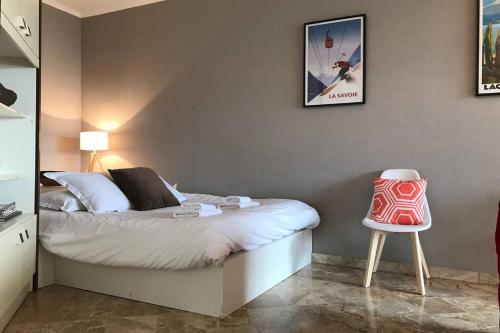 une petite chambre avec un lit et une chaise dans l'établissement CHEZ JACQUES - terrasse avec vue lac et montagne, à Annecy