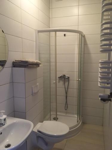 een badkamer met een douche, een toilet en een wastafel bij Studio CENTRUM Szczytno Mazury 2 in Szczytno
