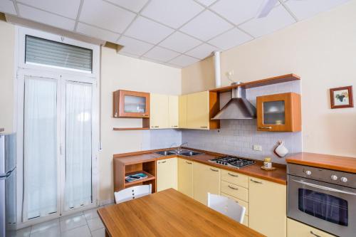 a kitchen with yellow cabinets and a wooden table at Residence Daniele in Bellaria-Igea Marina