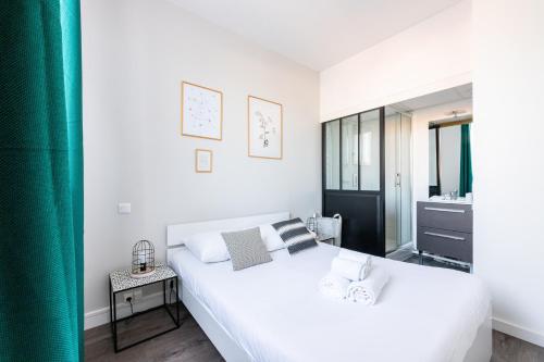 - une chambre blanche avec un grand lit et une salle de bains dans l'établissement LES HALLES NANTAISES - marché de Talensac, à Nantes