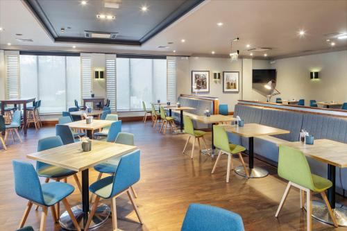 
a restaurant with tables and chairs in it at Holiday Inn Peterborough West, an IHG Hotel in Peterborough
