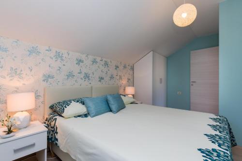 een slaapkamer met een groot wit bed met blauwe bloemen bij Cetinic Apartment in Dubrovnik