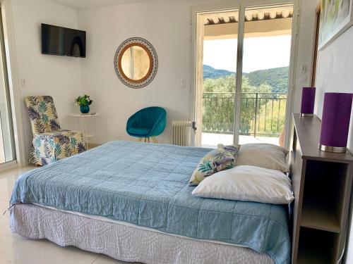 a bedroom with a blue bed and a balcony at Villa Grand Baie in Agay - Saint Raphael