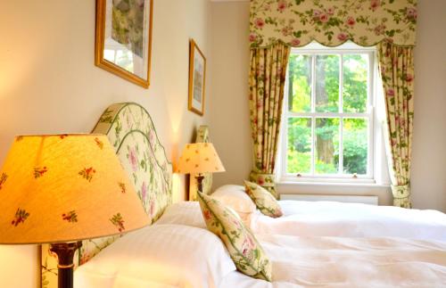 a bedroom with two beds and a window at Delphi Lodge in Leenaun