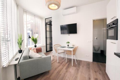a living room with a couch and a table at Charming beach getaway in Scheveningen