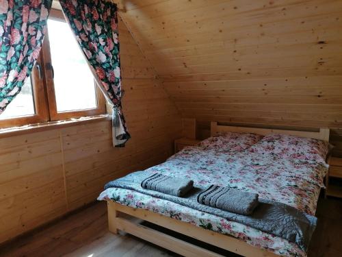1 dormitorio con 1 cama en una cabaña de madera en Domek na wzgórzu "WILK", en Świątkowa Mała