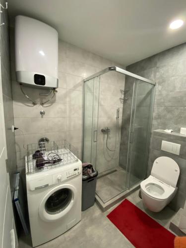 uma casa de banho com uma máquina de lavar roupa e um chuveiro em Apartment Nena em Trebinje