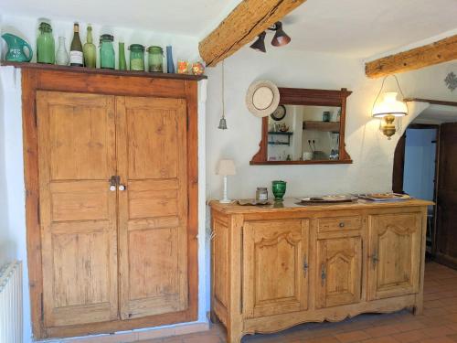 a kitchen with a large wooden cabinet and a counter at Le Mas du Tes in Saint Sebastien d'Aigrefeuille