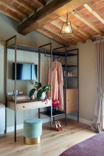 a room with a bed with a desk and a dressing table at Borgo I Vicelli Adults Only Relais in Bagno a Ripoli