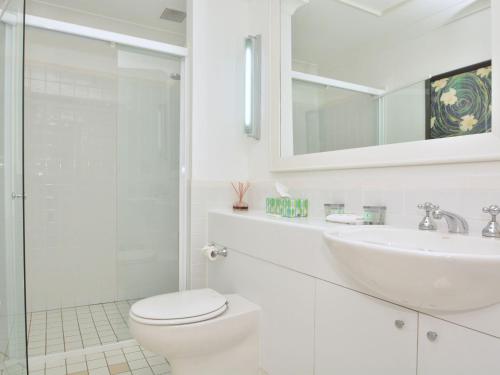 a white bathroom with a toilet and a sink at Villa 3br Margarita Villa located within Cypress Lakes Resort in Pokolbin