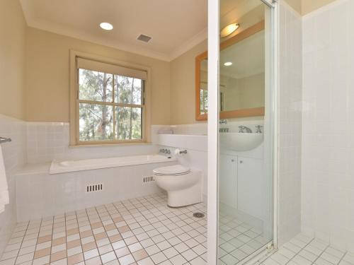 uma casa de banho com um WC, uma banheira e um lavatório. em Villa 3br Tempranillo Villa located within Cypress Lakes Resort em Pokolbin