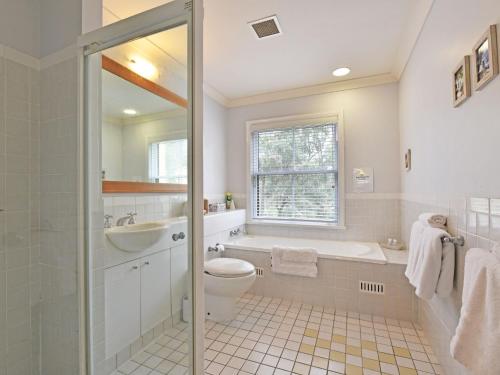 a bathroom with a toilet and a sink and a tub at Villa 3br Penivity Villa located within Cypress Lakes Resort in Pokolbin