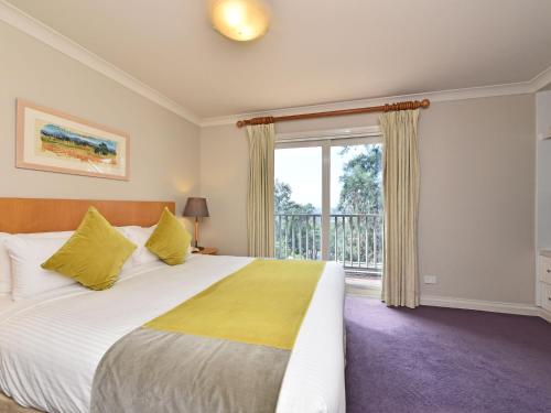 een slaapkamer met een groot bed en een balkon bij Villas Dodici Sleeps 12 2X3br Resort Condos located within Cypress Lakes Resort nothing is more central in Pokolbin