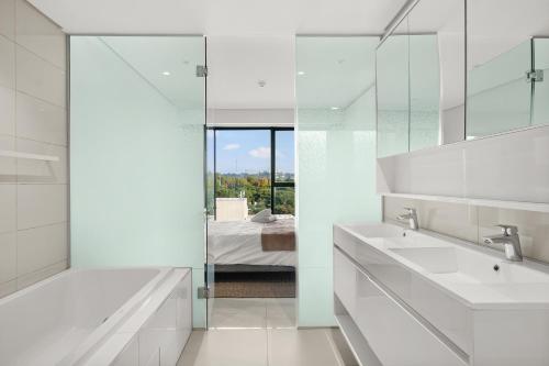 Baño blanco con 2 lavabos y espejo en The Park Central Residence - WITH GENERATOR, en Johannesburgo