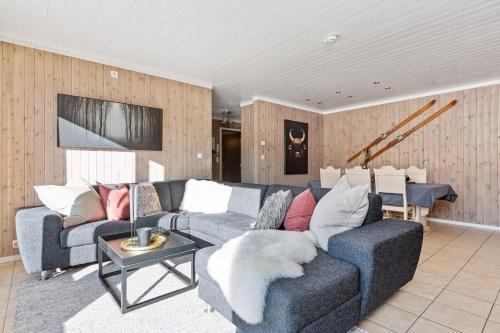 uma sala de estar com um sofá e uma mesa em In the middle of Trysilfjellet - Welcome Center - Apartment with 3 bedrooms - By bike arena and ski lift em Trysil