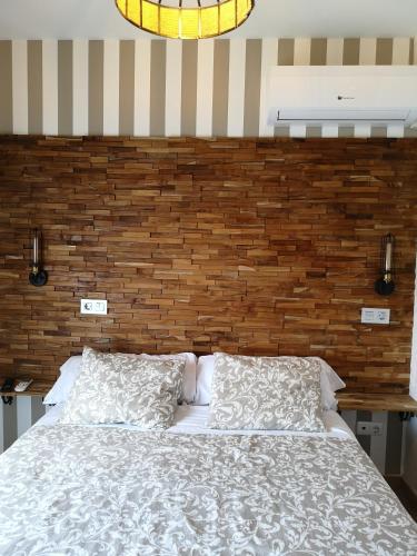a bedroom with a bed and a brick wall at Hostal Juan Bravo in Segovia