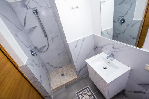 a white bathroom with a shower and a sink at Residence Daniele in Bellaria-Igea Marina