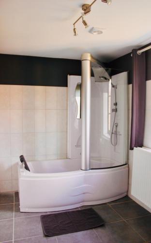 a bathroom with a bath tub in a room at Les Lilas in Sart-en-Fagne