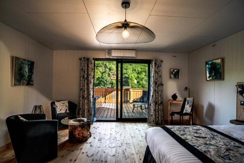 1 dormitorio con 1 cama y puerta corredera de cristal en Le Volcan des Sens, chambres d'hotes de luxe et SPA, en Torsiac