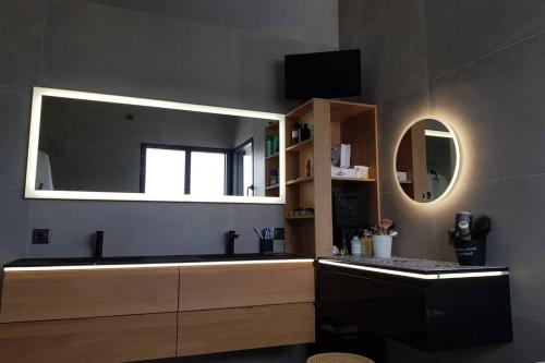 a bathroom with a sink and a mirror at La Villa Thelma 5 étoiles, piscine, sauna et jacuzzi in Granville