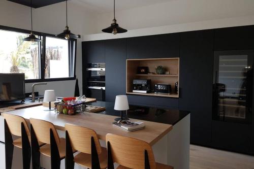 a kitchen with a dining room table with chairs at La Villa Thelma 5 étoiles, piscine, sauna et jacuzzi in Granville