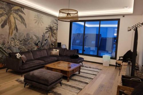 a living room with a couch and a coffee table at La Villa Thelma 5 étoiles, piscine, sauna et jacuzzi in Granville