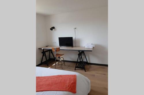 a room with a desk with a computer and a bed at La Villa Thelma 5 étoiles, piscine, sauna et jacuzzi in Granville