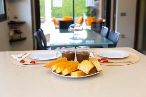 a plate of bread and two glasses of tea on a table at La Cantera Rural Spa in Viñaixa